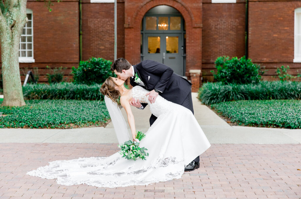Bride and groom walking hand in hand outside Venue 1902 in Sanford, FL, during their summer wedding.
